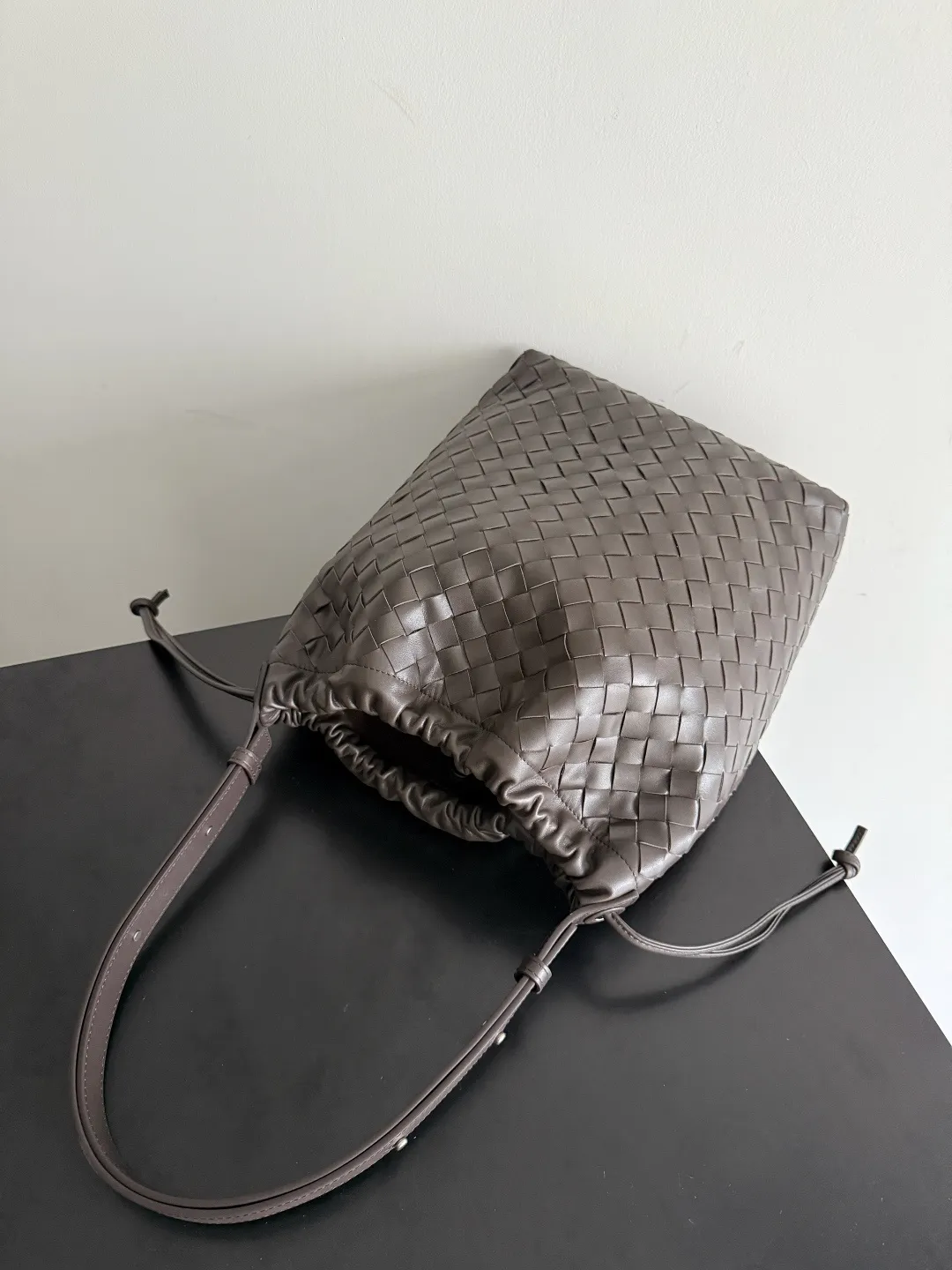 Batch 2280 BOTTEGA VENETA2025 new woven Biblioteca Bucket perfectly integrates casual texture, using classic Intrecciato woven leather, which feels soft but stiff, allowing the bag to drape naturally without losing the three-dimensional effect. The drawstring design of the drawstring pocket makes opening and closing more direct and adds a casual atmosphere. If you are on a short business trip, you can put some skin care samples in your bag. The front compartment or rear zipper can also be used to store ID cards, bank cards, etc. The solid color design of the bag is very versatile, and it doesn’t feel too picky when paired with any clothes. The leather material is also very high-quality! Style number: 836020 Size: 24*33*14cm